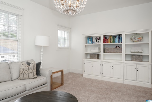 living area with a chandelier, baseboards, and light colored carpet