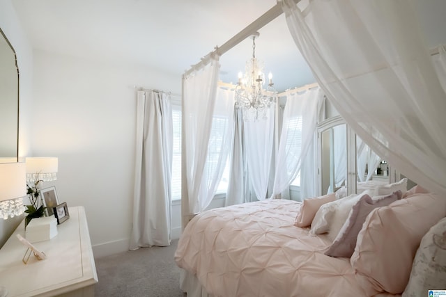 carpeted bedroom with baseboards and a chandelier