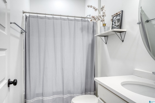 bathroom featuring curtained shower, vanity, and toilet