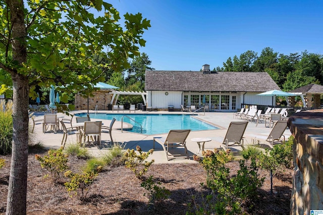 community pool with fence, a pergola, and a patio