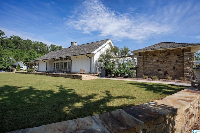 view of home's exterior with a lawn, a chimney, and cooling unit