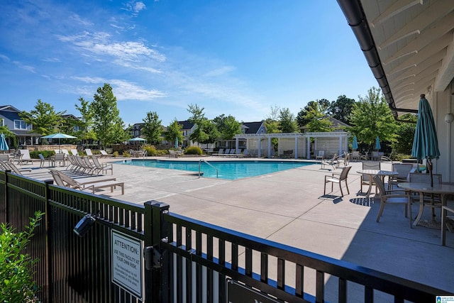 community pool with a patio area and fence