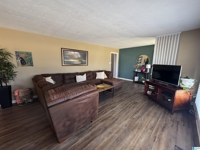 living room featuring a textured ceiling, baseboards, and wood finished floors