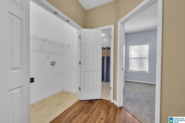 laundry area featuring laundry area, washer hookup, wood finished floors, and baseboards