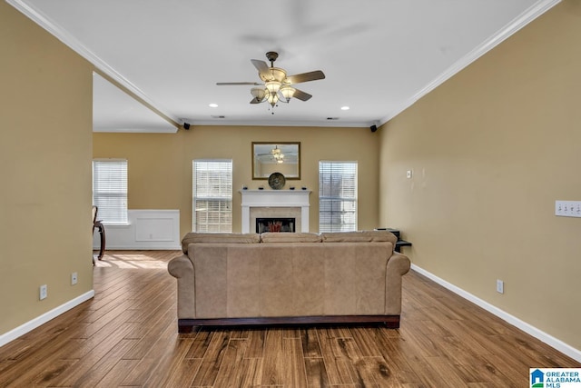 living area with baseboards, dark wood-type flooring, a fireplace, and crown molding