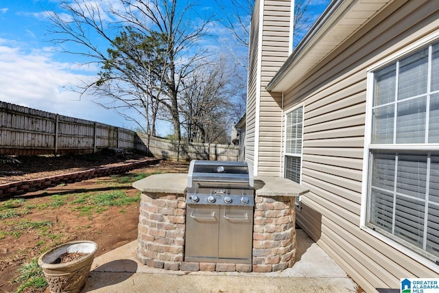 view of patio featuring a fenced backyard, an outdoor kitchen, and area for grilling