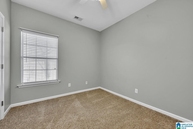 spare room featuring carpet floors, baseboards, visible vents, and ceiling fan