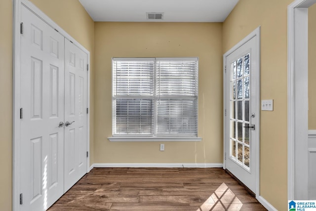 interior space featuring dark wood-type flooring, visible vents, and baseboards