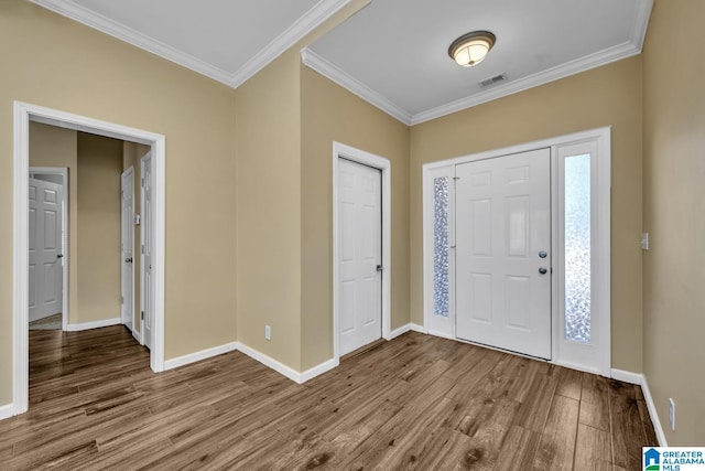 entryway featuring visible vents, crown molding, baseboards, and wood finished floors