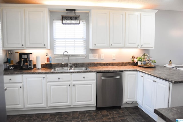 kitchen featuring a peninsula, a sink, white cabinets, stainless steel dishwasher, and dark countertops