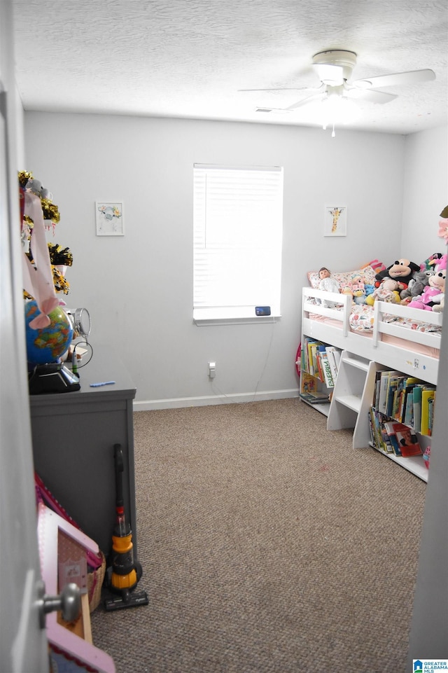 bedroom featuring carpet floors, ceiling fan, a textured ceiling, and baseboards