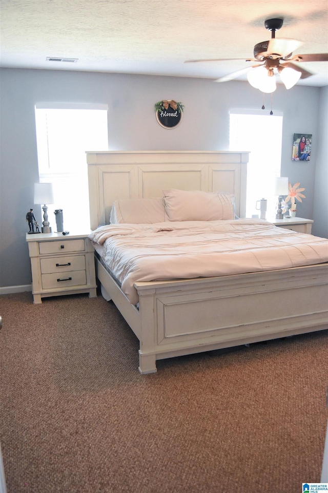 bedroom with a ceiling fan, baseboards, visible vents, and carpet flooring