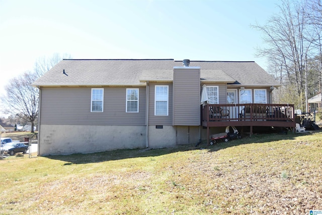 back of house with a deck, a shingled roof, and a lawn