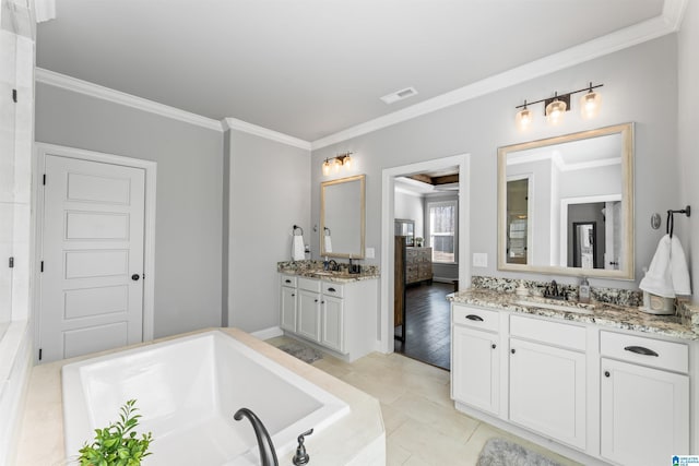 bathroom with a bathtub, two vanities, visible vents, ornamental molding, and a sink