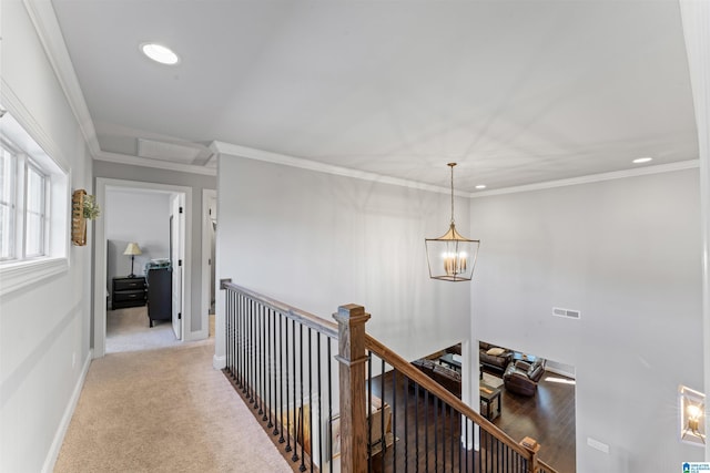 corridor with light carpet, visible vents, an inviting chandelier, crown molding, and an upstairs landing