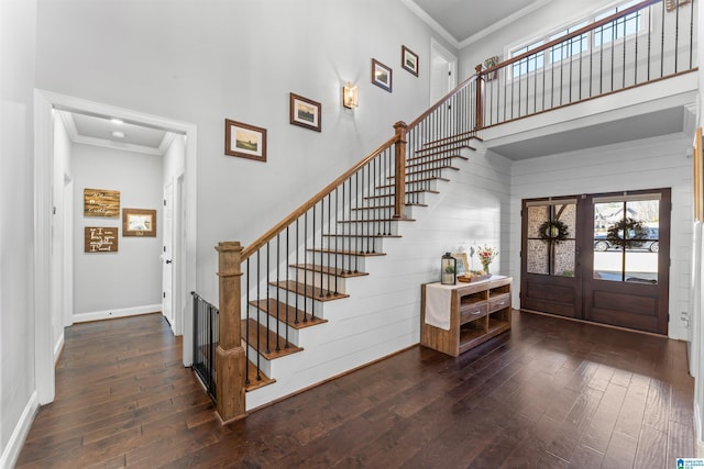 entryway with wood-type flooring, a high ceiling, stairway, and crown molding