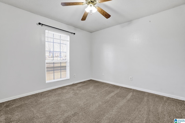 empty room featuring dark carpet, baseboards, and ceiling fan