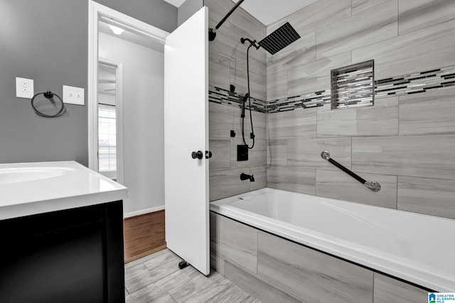 bathroom featuring tiled shower / bath combo and vanity