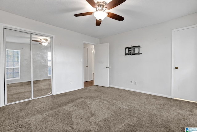 unfurnished bedroom with ceiling fan, carpet floors, a closet, and baseboards