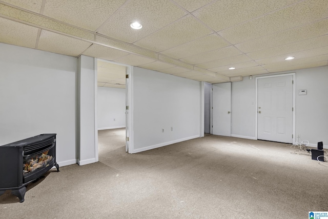 finished basement featuring recessed lighting, carpet, a wood stove, and baseboards