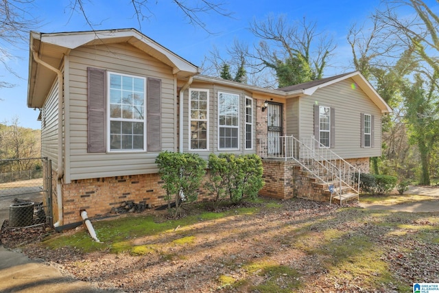 view of front facade featuring central AC, crawl space, and fence