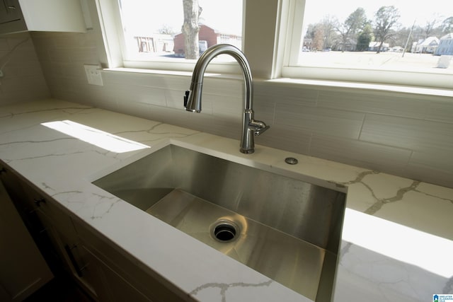 details with a sink and light stone countertops