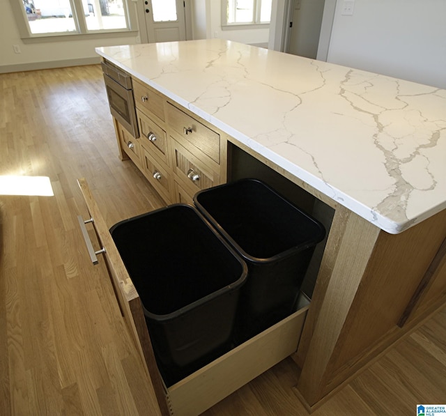 kitchen featuring light wood finished floors and light stone counters