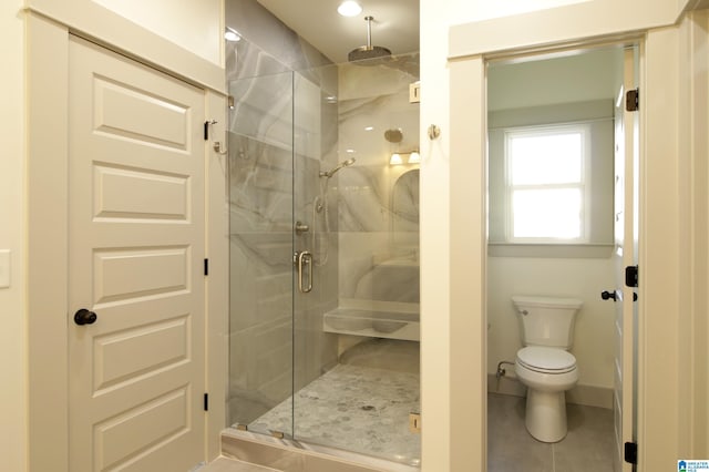 bathroom with toilet, tile patterned flooring, a marble finish shower, and baseboards