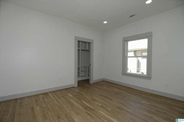 unfurnished room with baseboards, recessed lighting, visible vents, and light wood-style floors