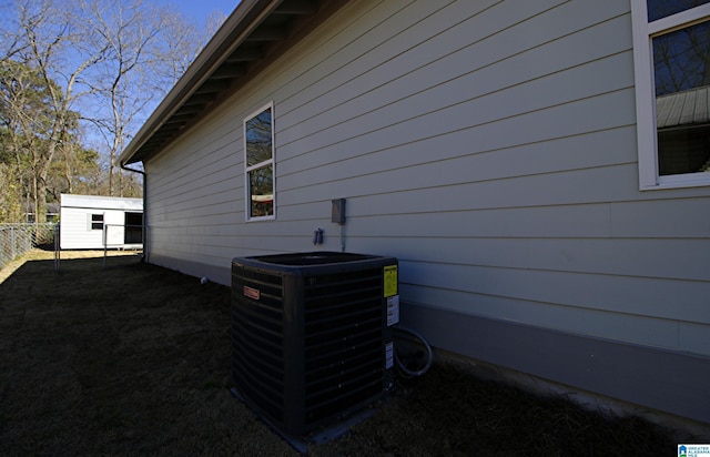 view of home's exterior featuring a yard, central air condition unit, a storage shed, fence, and an outdoor structure