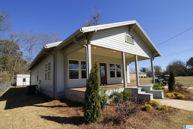 view of home's exterior with a porch, fence, and central air condition unit