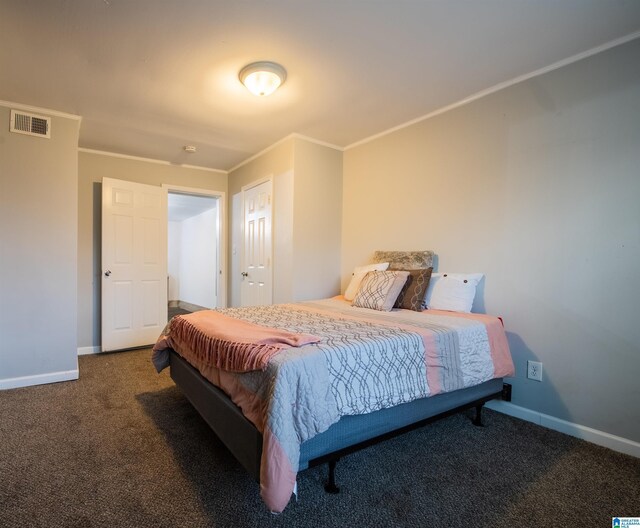 carpeted bedroom featuring visible vents, baseboards, and crown molding