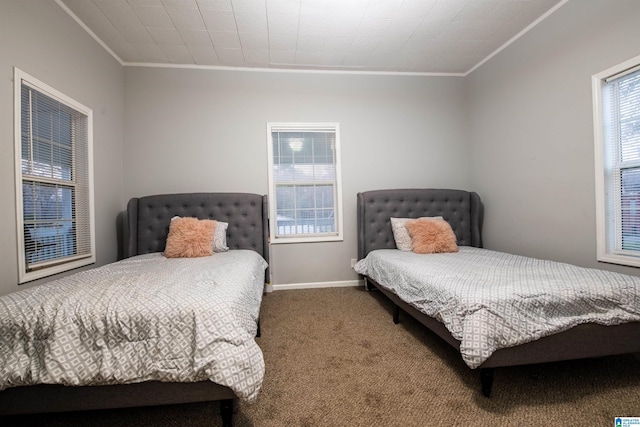 carpeted bedroom featuring crown molding and baseboards