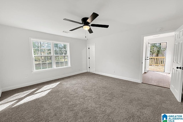 carpeted empty room with visible vents, baseboards, and a ceiling fan