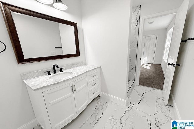 bathroom with marble finish floor, vanity, visible vents, and baseboards