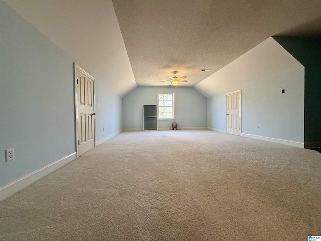 bonus room with ceiling fan, carpet, baseboards, and vaulted ceiling