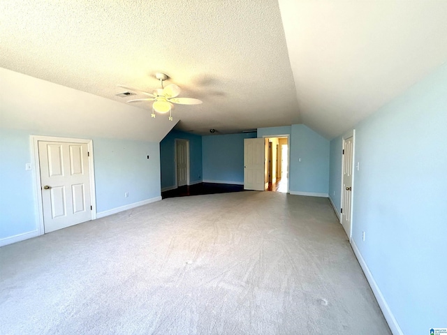 additional living space featuring lofted ceiling, visible vents, and a textured ceiling