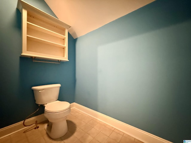 bathroom featuring lofted ceiling, toilet, and baseboards