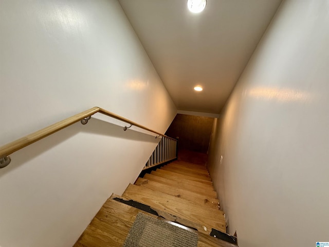 stairway featuring radiator and wood finished floors