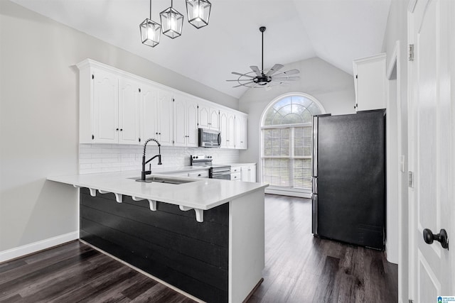 kitchen with stainless steel appliances, decorative backsplash, vaulted ceiling, a sink, and a peninsula