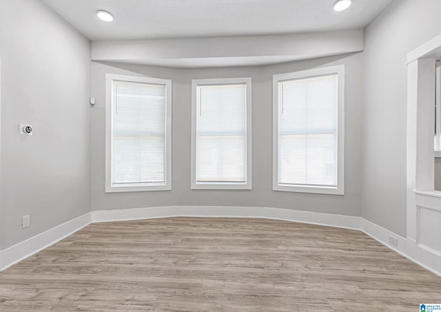 unfurnished room with light wood-style flooring, baseboards, and recessed lighting