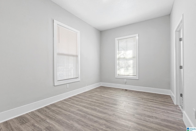 spare room with wood finished floors and baseboards