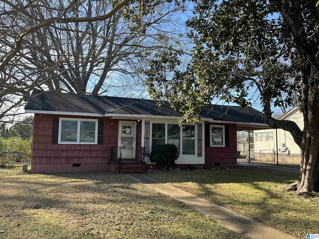 ranch-style house featuring a carport, crawl space, and a front lawn