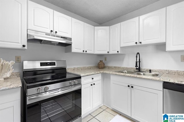 kitchen with appliances with stainless steel finishes, white cabinets, a sink, and under cabinet range hood