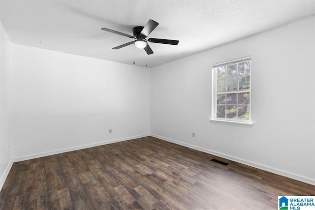 unfurnished room with a ceiling fan, wood finished floors, visible vents, and baseboards