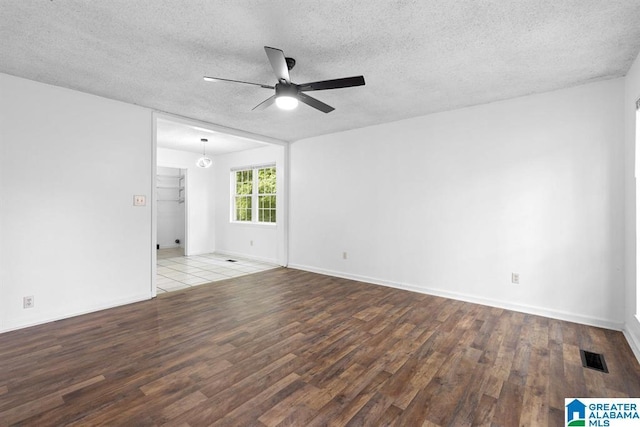 spare room featuring visible vents, ceiling fan, a textured ceiling, and wood finished floors