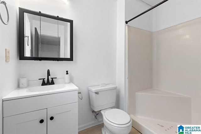 bathroom featuring a stall shower, vanity, and toilet