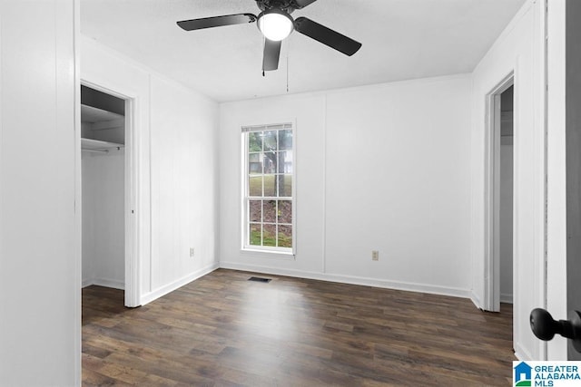 unfurnished bedroom featuring a closet, visible vents, a ceiling fan, wood finished floors, and baseboards