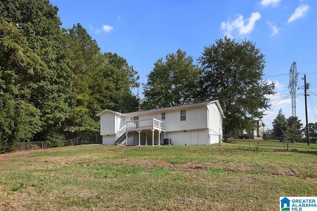 view of front facade with stairs, fence, a front lawn, and a wooden deck