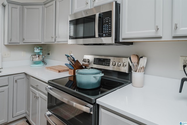 kitchen featuring appliances with stainless steel finishes, light countertops, and gray cabinetry